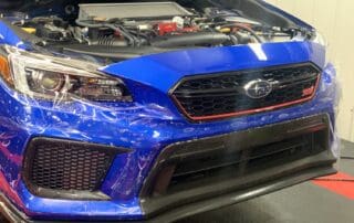 Clear Bra being applied to a blue Subaru by Abundance Auto Detail in Murfreesboro