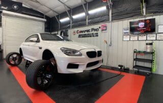 white bmw with wheels off to get detailed